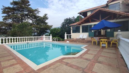 una piscina frente a una casa en New Paradise Casa Campestre, en Villeta