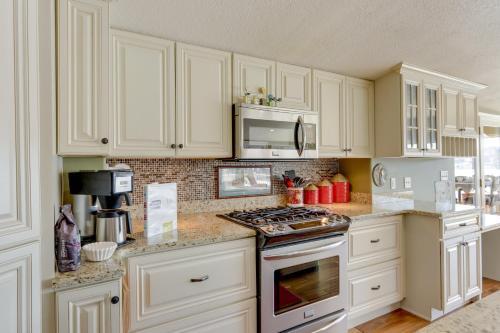a kitchen with white cabinets and a stove top oven at Waterfront Lake of the Ozarks Home with Private Dock in Roach