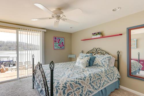 a bedroom with a bed and a ceiling fan at Waterfront Lake of the Ozarks Home with Private Dock in Roach