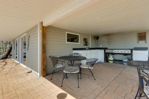 a patio with a table and chairs and a kitchen at Waterfront Lake of the Ozarks Home with Private Dock in Roach