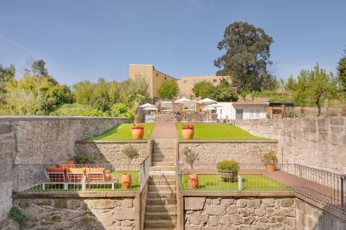 een stenen muur met een patio en een tuin bij Santa Catarina - Pool & Fitness, by Oporto Collection - Adults Only in Porto