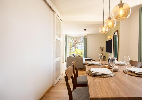 a dining room and living room with a table and chairs at Magnifique 3 pièces - Proximité Place des Lices avec parking in Saint-Tropez