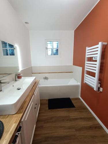 une salle de bain avec une baignoire blanche et un lavabo dans l'établissement Maison Fourat, à Saint-Martin-du-Bois