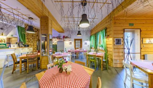 un restaurante con paredes de madera, mesas y sillas en Apartamenty Czerwone Korale, en Cielimowo