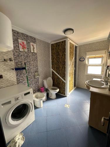 a bathroom with a washing machine and a toilet and a sink at Nice Apartement au cornich de nador in Nador