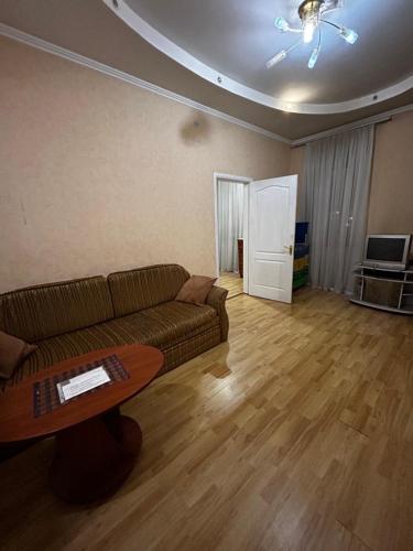 ein Wohnzimmer mit einem Sofa und einem Tisch in der Unterkunft Apartment near train station and close to city center in Kiew