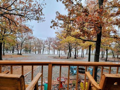 a deck with a view of a park with trees at Bristow Blue - Lake front with Boat Ramp Access!! in Canadian