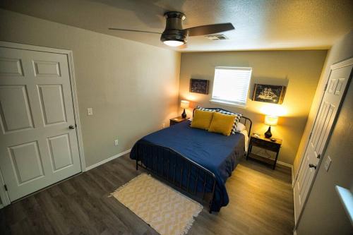 Schlafzimmer mit einem Bett mit blauer Bettwäsche und gelben Kissen in der Unterkunft Bristow Blue - Lake front with Boat Ramp Access!! in Canadian