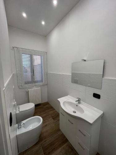 a white bathroom with a sink and a toilet at Il villino di nonna Domenica in Lecce