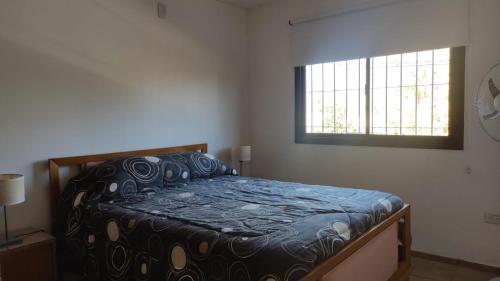 a bedroom with a bed and a window at Finde y Vacaciones in San Rafael