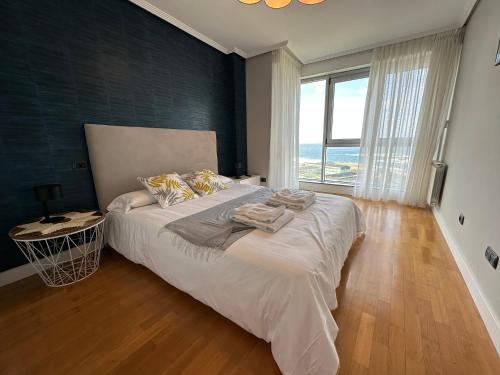ein Schlafzimmer mit einem großen Bett und einem großen Fenster in der Unterkunft Hercules Town BY Oktheway in A Coruña