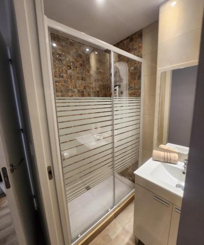 a bathroom with a glass shower and a sink at Apartamentos en Alameda junto al Corte Inglés in Cartagena