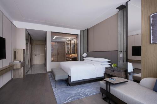a bedroom with a bed and a living room at Foshan Marriott Hotel in Foshan