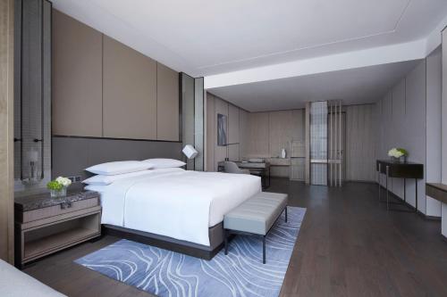 a bedroom with a large white bed and a bathroom at Foshan Marriott Hotel in Foshan
