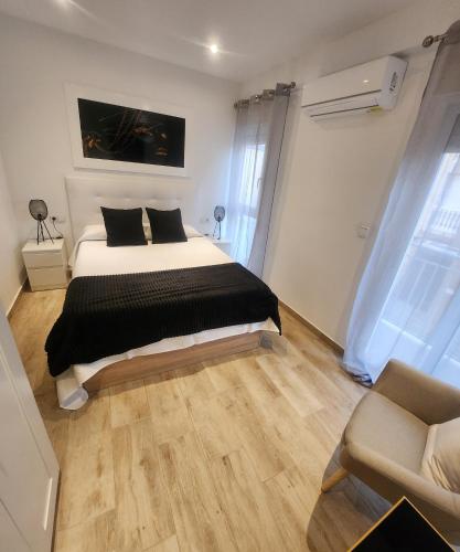 a bedroom with a bed and a chair in it at Apartamentos en Alameda junto al Corte Inglés in Cartagena