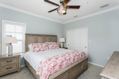een slaapkamer met een bed en een plafondventilator bij Beach Happy in Pensacola