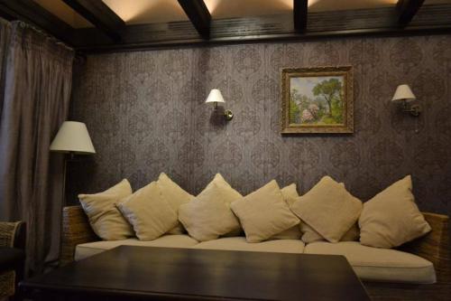 a living room with a couch with pillows at Gogol Hotel in Myrhorod