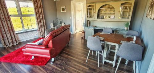 a living room with a red couch and a table at Tully View House in Donegal