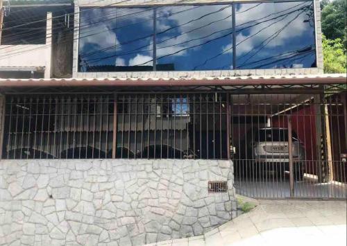 a cage in front of a building with a truck in it at Linda Casa com Estacionamento in Juiz de Fora