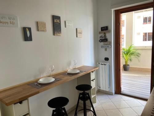 a kitchen with a counter with two sinks and two stools at AGM Suite Rome Airport Leonardo in Fiumicino