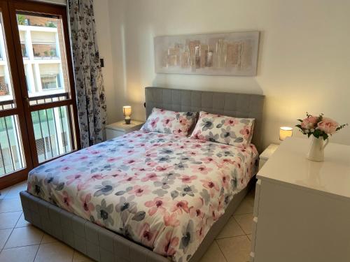 een slaapkamer met een bed met een bloemdekbed bij AGM Suite Rome Airport Leonardo in Fiumicino