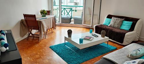 - un salon avec un canapé et une table dans l'établissement EXCEPTIONNEL "A NOUS PARIS" ! Spacieux - Calme - Balcon - Wifi - Netflix - Parking, à Rueil-Malmaison