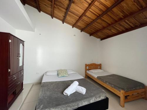 1 dormitorio con 2 camas y techo de madera en Apartamento en San Gil con parqueadero privado en San Gil