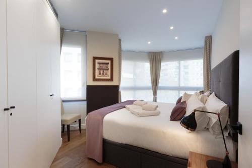 una camera con un grande letto e una finestra di RAMBLA POBLENOU Luxury a Barcellona