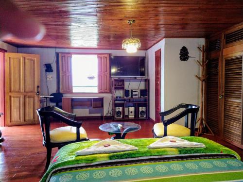ein Schlafzimmer mit 2 Betten und einem Tisch darin in der Unterkunft Parque Bioflora in Dosquebradas