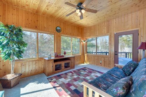 a living room with a couch and a ceiling fan at Bright Minong Vacation Rental on Little Sand Lake! in Minong