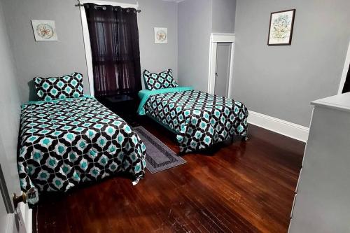 1 Schlafzimmer mit 2 Betten und Holzboden in der Unterkunft Comfortable 3 bedroom home with private parking! in Elmira
