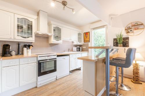 une cuisine avec des armoires blanches et un comptoir dans l'établissement Cosy cocoon - Fairytale Factory, à Bussy-Saint-Georges