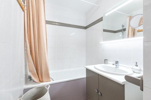 une salle de bain blanche avec un lavabo et une baignoire dans l'établissement Cosy cocoon - Fairytale Factory, à Bussy-Saint-Georges