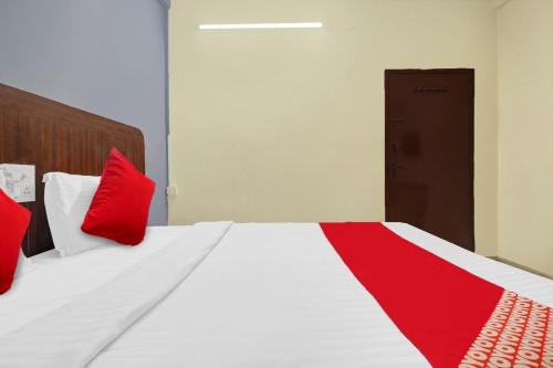 a bedroom with a bed with red pillows on it at Hotel O HRR Hotels Near Paradise circle in Hyderabad