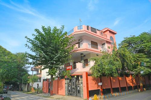 un bâtiment rose sur le côté d'une rue dans l'établissement OYO Flagship Hotel Baba''s House, à Kakarmatha
