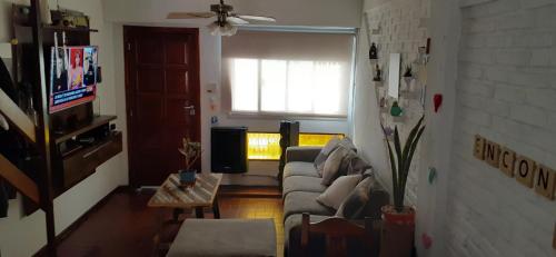 sala de estar con sofá y TV en mar mel1 en Pinamar
