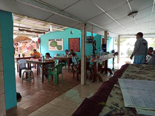 a group of people sitting at tables in a restaurant at Ometepe House in Moyogalpa