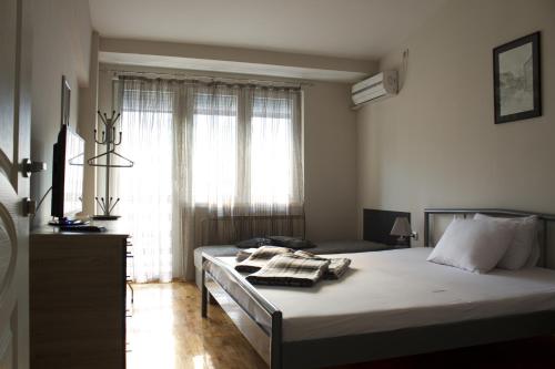 斯科普里的住宿－Guest house Kozle，一间卧室设有一张大床和一个窗户。