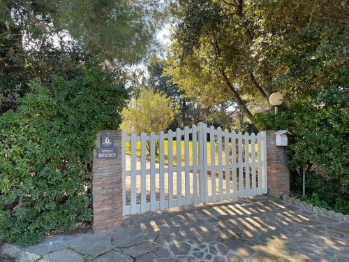 a white picket fence with a gate in a yard at Maison Antoinette in San Vincenzo