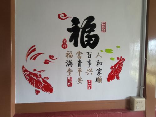 una pared con caracteres chinos y peces en ella en J ancient house, en Lucao