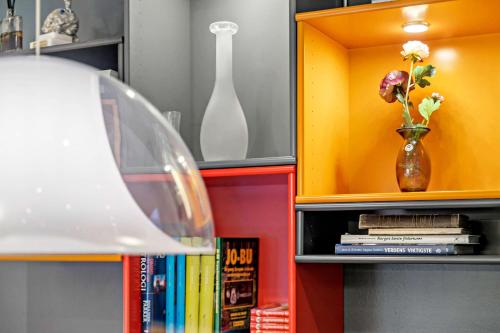 a book shelf with a vase with flowers in it at Best Western Leto Arena in Dal
