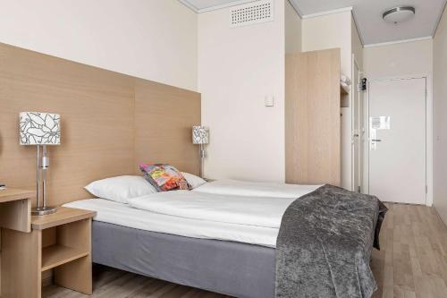 a bedroom with a large bed and a desk with a lamp at Best Western Leto Arena in Dal