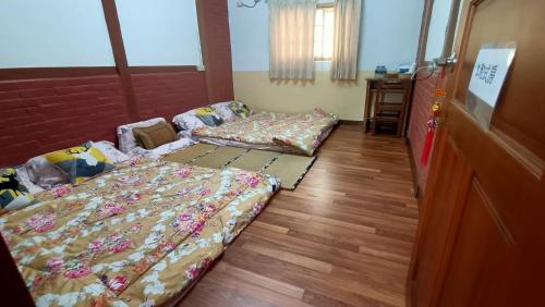 a room with two beds and a table in it at J ancient house in Lucao
