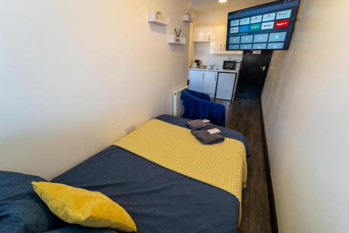 Un dormitorio con una cama y un televisor de pantalla plana. en Modern Studio 10 mins on train to City!, en Birmingham
