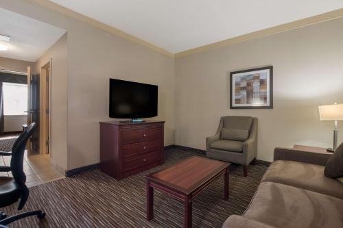 a hotel room with a couch and a tv and a chair at Best Western Brantford Hotel and Conference Centre in Brantford