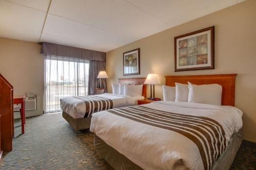 ein Hotelzimmer mit 2 Betten und einem Fenster in der Unterkunft Best Western Brantford Hotel and Conference Centre in Brantford