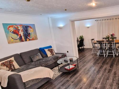 a living room with a couch and a table at Spacious & comfy Home- very close to NEC Birmingham ,HS2 & Airport- Perfect for contractors & groups- free parking & Fast WiFi in Marston Green