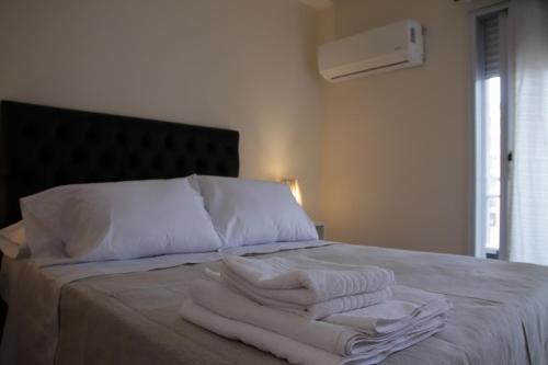a bed with white towels sitting on top of it at Parana 540 - Nueva Córdoba in Cordoba
