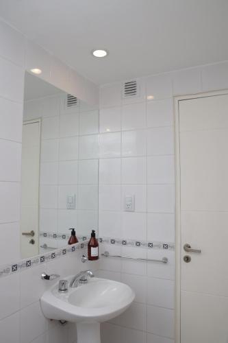 uma casa de banho branca com um lavatório e um chuveiro em Parana 540 - Nueva Córdoba em Córdova