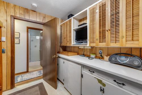 a kitchen with wooden cabinets and a counter top at Water's Edge Oceanside Home in Waldport